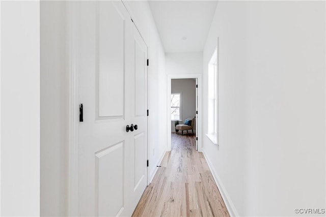 hall with light wood finished floors and baseboards