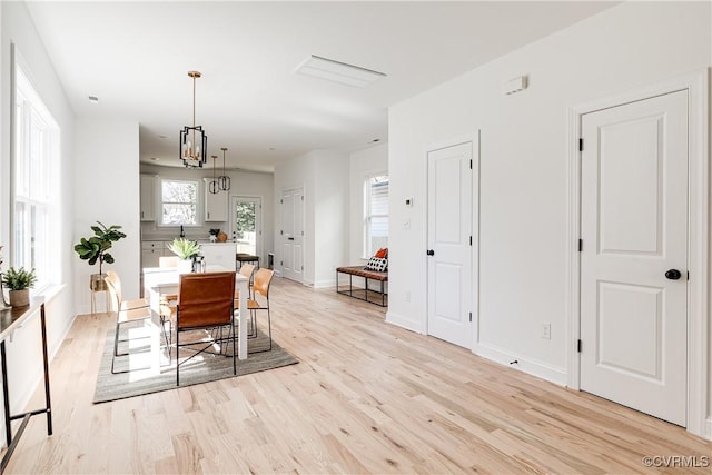 dining area with light wood finished floors and baseboards