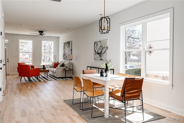 dining area with visible vents, a ceiling fan, light wood-style flooring, and baseboards