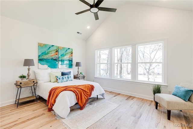 bedroom featuring high vaulted ceiling, light wood-type flooring, visible vents, and baseboards