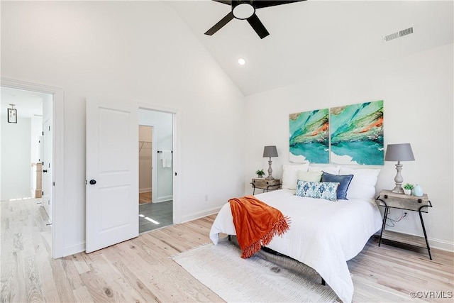 bedroom with high vaulted ceiling, light wood-type flooring, visible vents, and baseboards