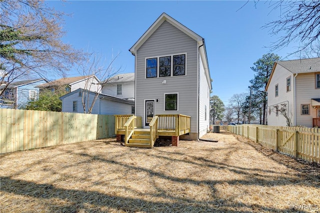 rear view of house with a deck, central AC unit, and a fenced backyard