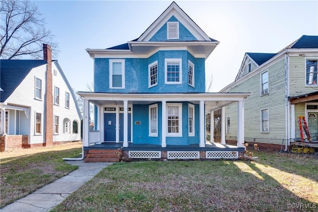 view of front of property with covered porch, a front lawn, and stucco siding