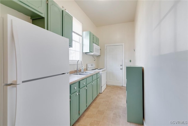 kitchen featuring white appliances, light countertops, a sink, and green cabinets