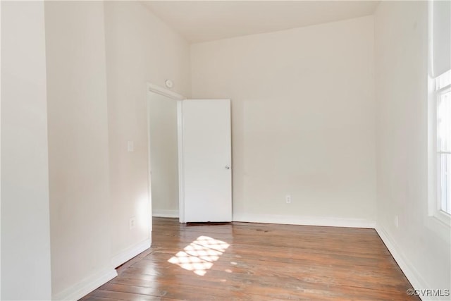 empty room with hardwood / wood-style flooring and baseboards