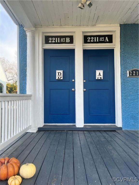 property entrance with a porch and stucco siding