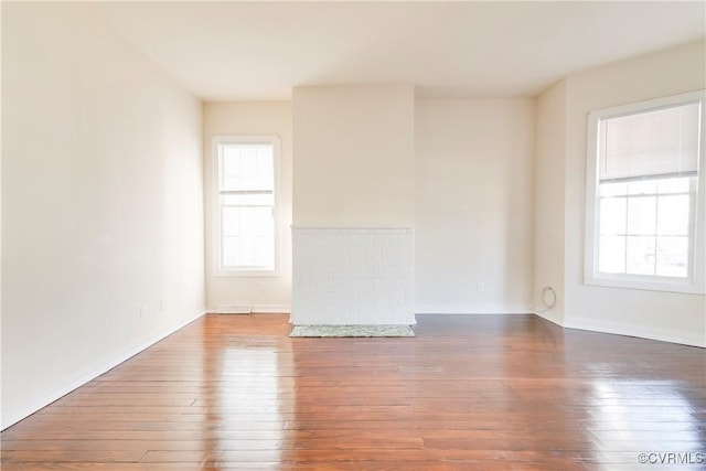 spare room with plenty of natural light and wood-type flooring