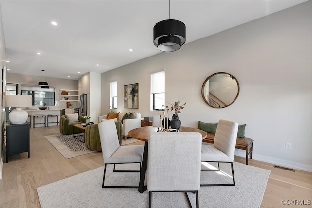 dining room featuring light wood-type flooring, visible vents, baseboards, and recessed lighting