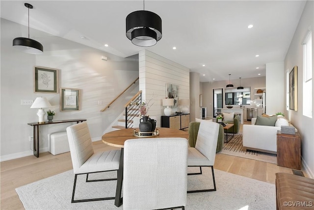 dining room featuring light wood-style flooring, stairway, baseboards, and recessed lighting