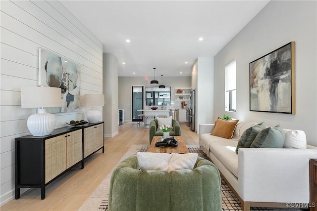 living area with recessed lighting, baseboards, and light wood finished floors