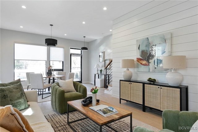 living room featuring light wood finished floors, stairs, and recessed lighting