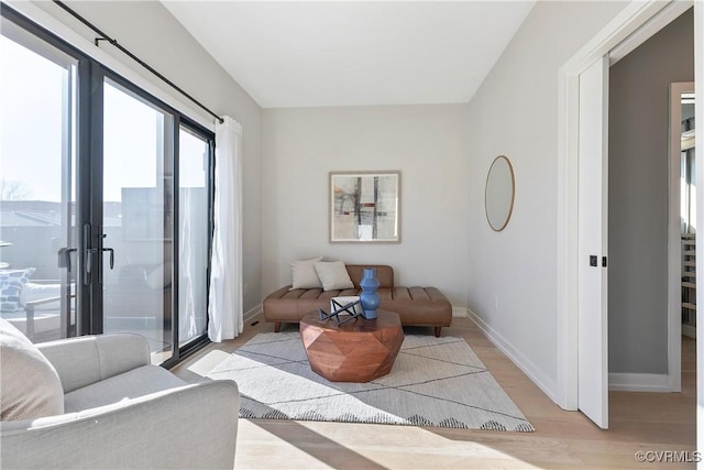 living area with baseboards and wood finished floors