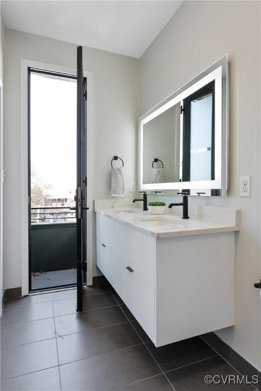 bathroom featuring double vanity, a sink, and tile patterned floors