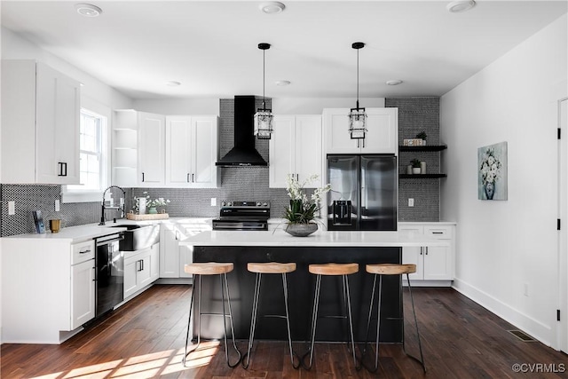 kitchen featuring open shelves, wall chimney range hood, a sink, and stainless steel appliances