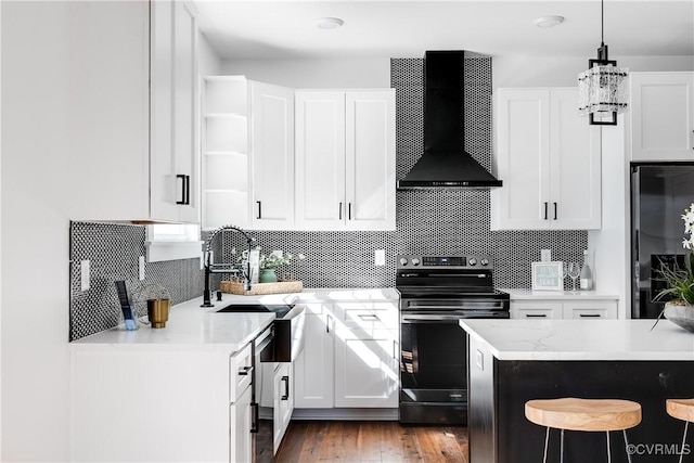 kitchen featuring electric range, refrigerator, wall chimney range hood, a kitchen bar, and open shelves