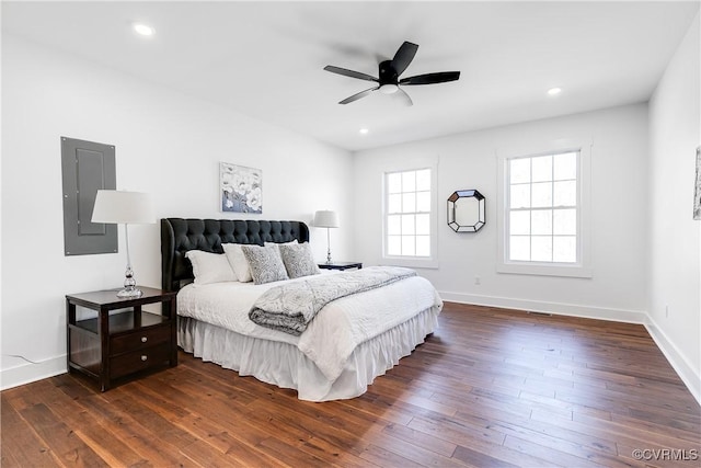 bedroom with dark wood-style floors, recessed lighting, electric panel, and baseboards