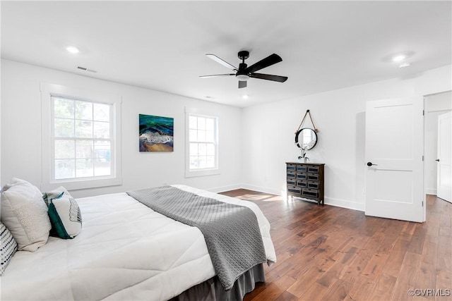 bedroom with recessed lighting, visible vents, baseboards, and wood finished floors