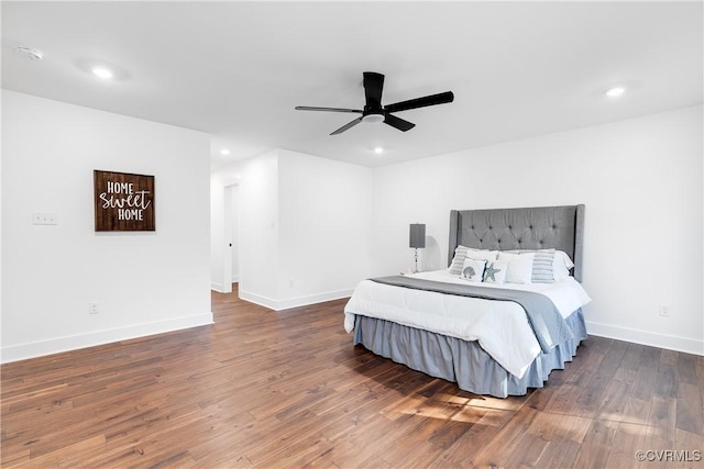 bedroom featuring baseboards, wood finished floors, and recessed lighting