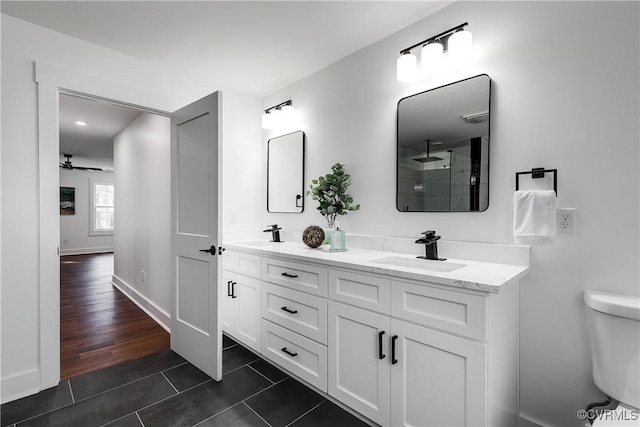 full bath with toilet, tile patterned flooring, double vanity, and a sink