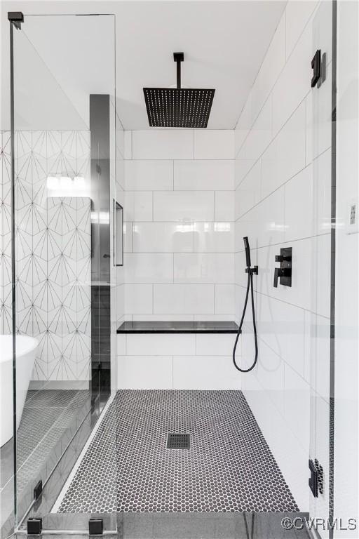 full bath featuring a stall shower, tile patterned flooring, and a soaking tub