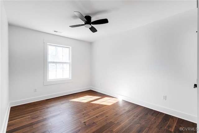 empty room featuring dark wood-style floors, baseboards, and a ceiling fan