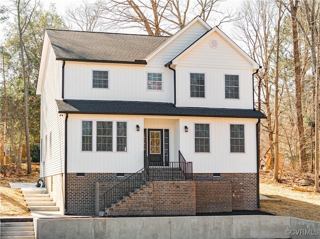 view of front facade featuring roof with shingles and crawl space