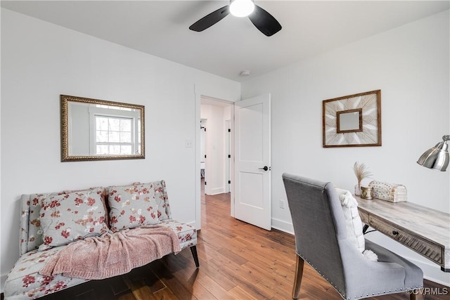 office featuring wood finished floors, a ceiling fan, and baseboards