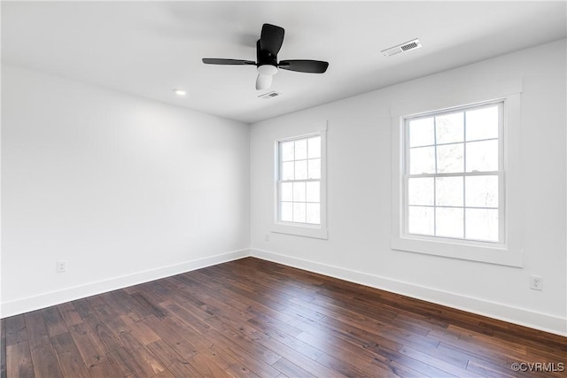 unfurnished room featuring visible vents, dark wood finished floors, baseboards, and ceiling fan