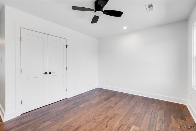 unfurnished bedroom featuring recessed lighting, visible vents, baseboards, a closet, and dark wood-style floors