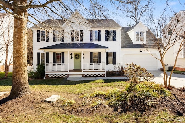 colonial home featuring driveway, a garage, a front lawn, and a porch