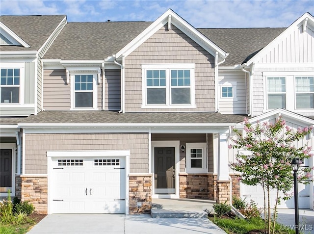 multi unit property featuring stone siding and roof with shingles