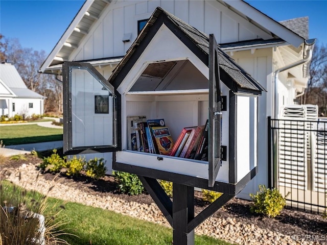 exterior space featuring board and batten siding, roof with shingles, and an outdoor structure