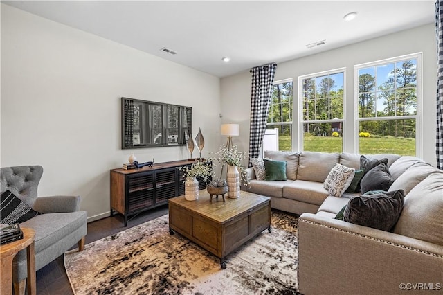 living room featuring baseboards, light wood-type flooring, visible vents, and recessed lighting