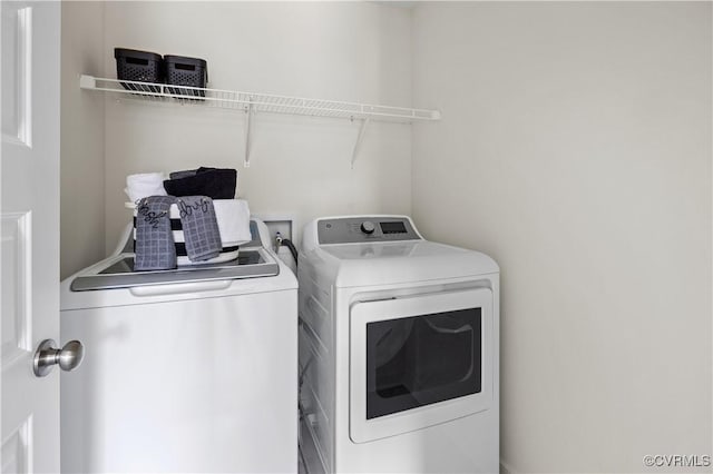 clothes washing area with washing machine and dryer and laundry area