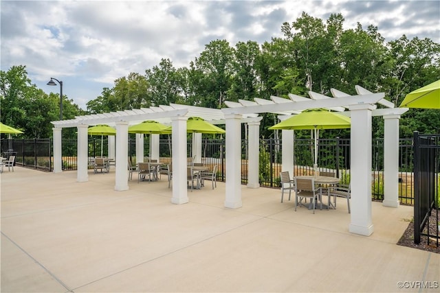 view of community featuring a patio, outdoor dining area, fence, and a pergola