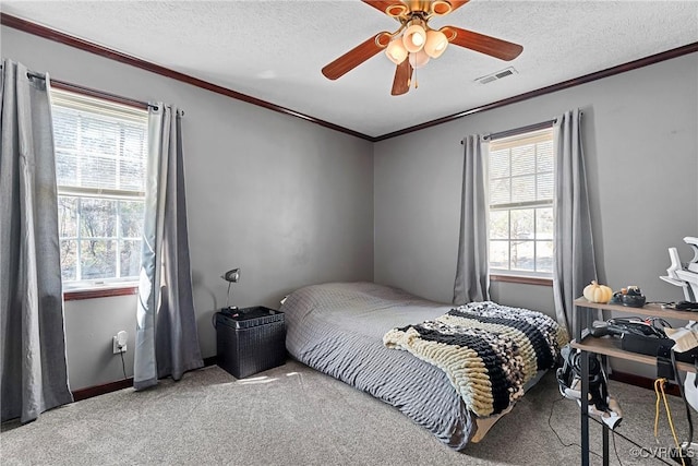 bedroom with carpet floors, visible vents, crown molding, and a textured ceiling