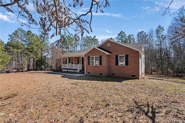 ranch-style house featuring covered porch, brick siding, and crawl space