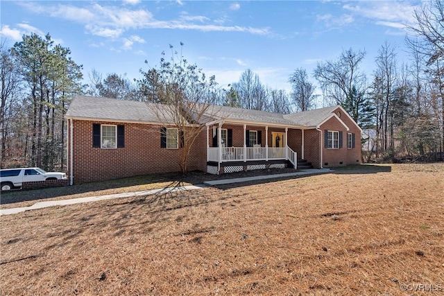 ranch-style home with a porch, crawl space, brick siding, and a front lawn