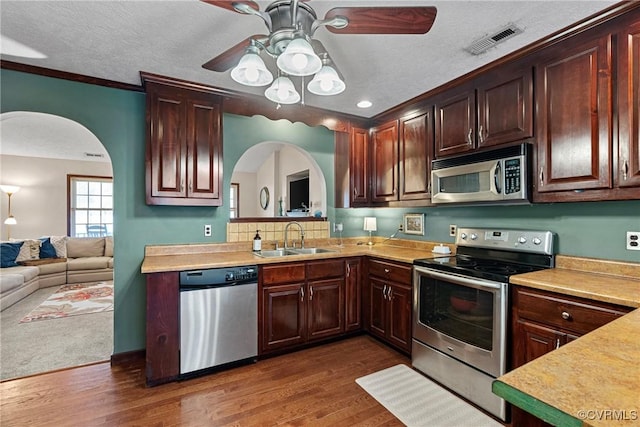 kitchen with visible vents, stainless steel appliances, a sink, and light countertops