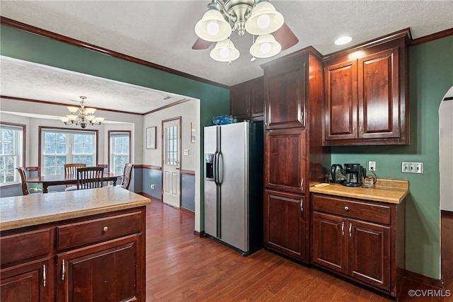 kitchen featuring dark wood-style flooring, stainless steel refrigerator with ice dispenser, light countertops, and ornamental molding