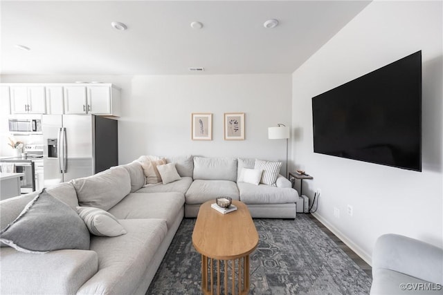 living area featuring visible vents and baseboards