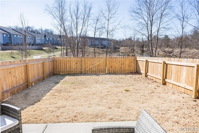 view of yard featuring a fenced backyard and a residential view