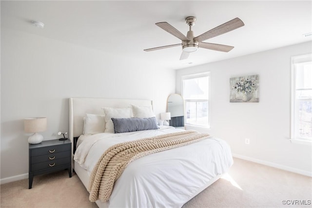 bedroom featuring a ceiling fan, light carpet, visible vents, and baseboards