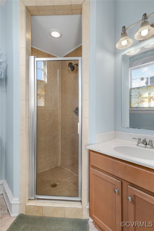 bathroom with vaulted ceiling, a shower stall, vanity, and tile patterned floors