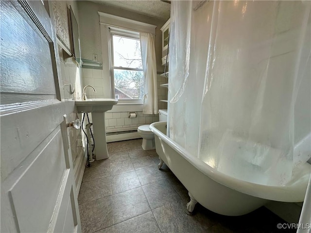 full bathroom featuring tile walls, toilet, a tub, a shower with curtain, and tile patterned floors