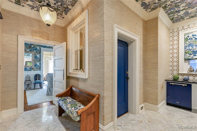 interior space with ornamental molding, baseboards, and wallpapered walls