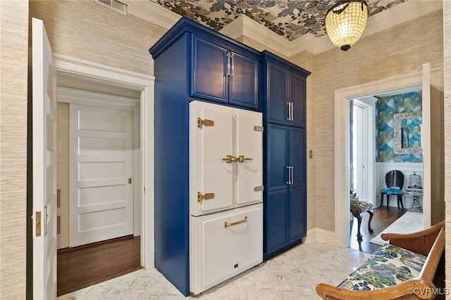 kitchen featuring blue cabinets, baseboards, and visible vents