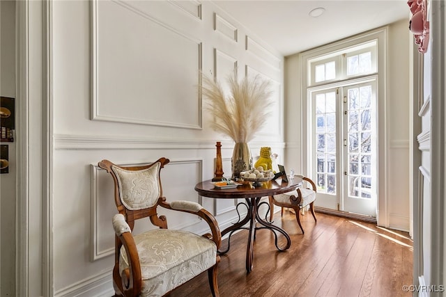 living area featuring a wealth of natural light, french doors, and hardwood / wood-style flooring