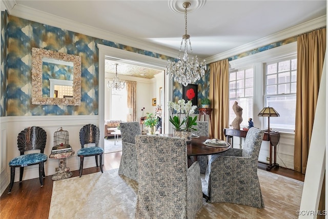 dining area featuring wallpapered walls, crown molding, a notable chandelier, and wainscoting