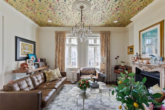 living area with a chandelier, a fireplace, wood finished floors, and crown molding